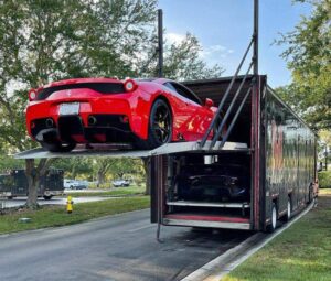 A red car loading into a trailer on a residential street